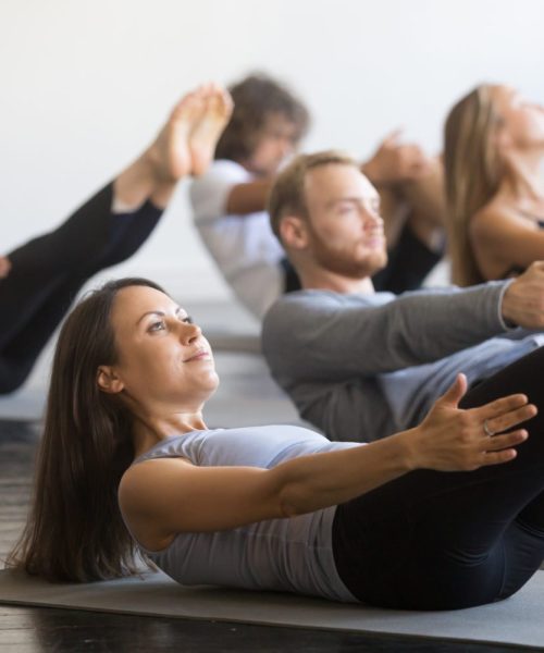 Groupe de jeunes sportifs pratiquant un cours de fitness avec un instructeur, faisant des exercices d’échauffement, pose du bateau, entraînement, étudiants s’entraînant dans un club, amis à un cours de fitness, intérieur, studio. Groupe de jeunes sportifs pratiquant un cours de fitness avec un instructeur, faisant des exercices d'échauffement, pose du bateau, entraînement, étudiants s'entraînant dans un club, amis à un cours de fitness, intérieur, studio.